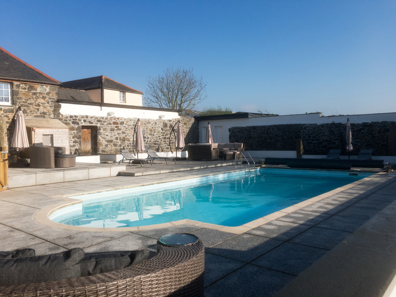 The heated outdoor pool with sun loungers and parasols