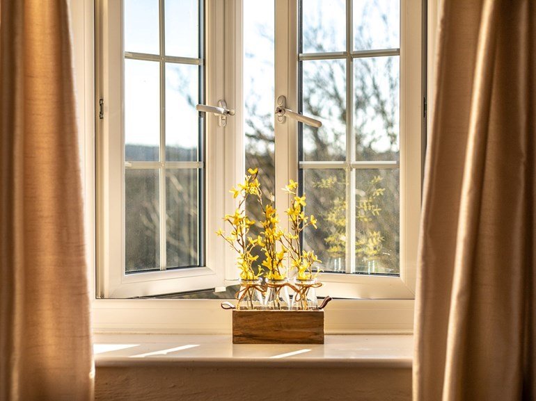 Sunlit cottage window with spring flowers