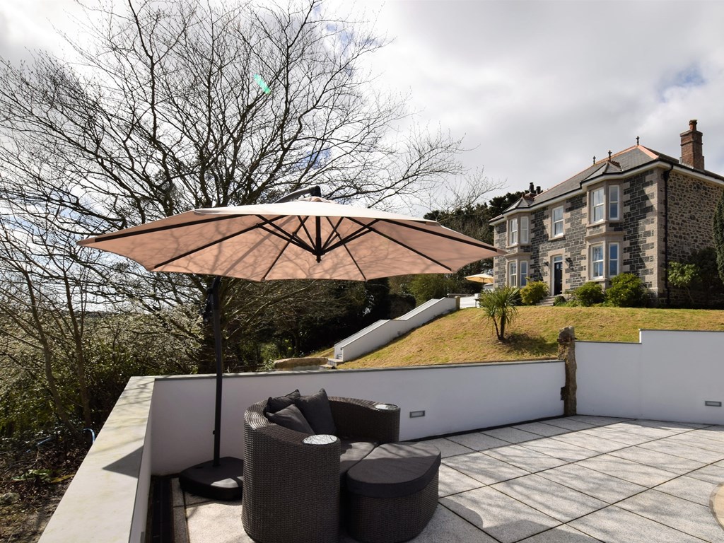 The pool terrace seating below the country house