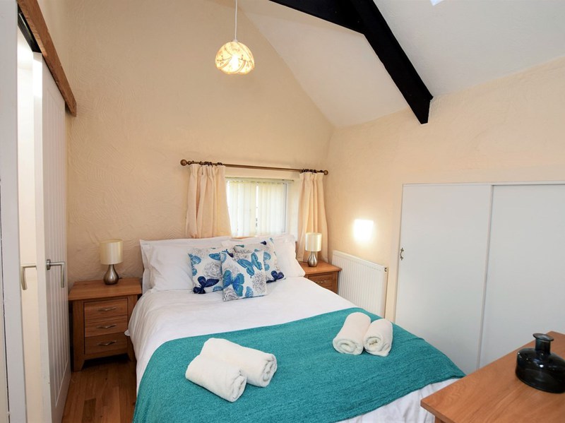 Double bedroom dressed in teal and butterfly cushions